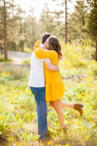 couples hugging in field of balsamroot