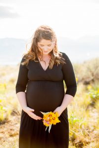 pregnant mother holding belly and flower in east wenatchee