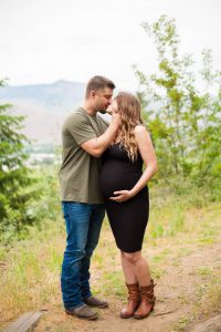 couple kissing as wife holds pregnant belly