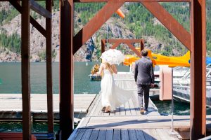 adventure elopement couple walking away from camera on dock in stehekin